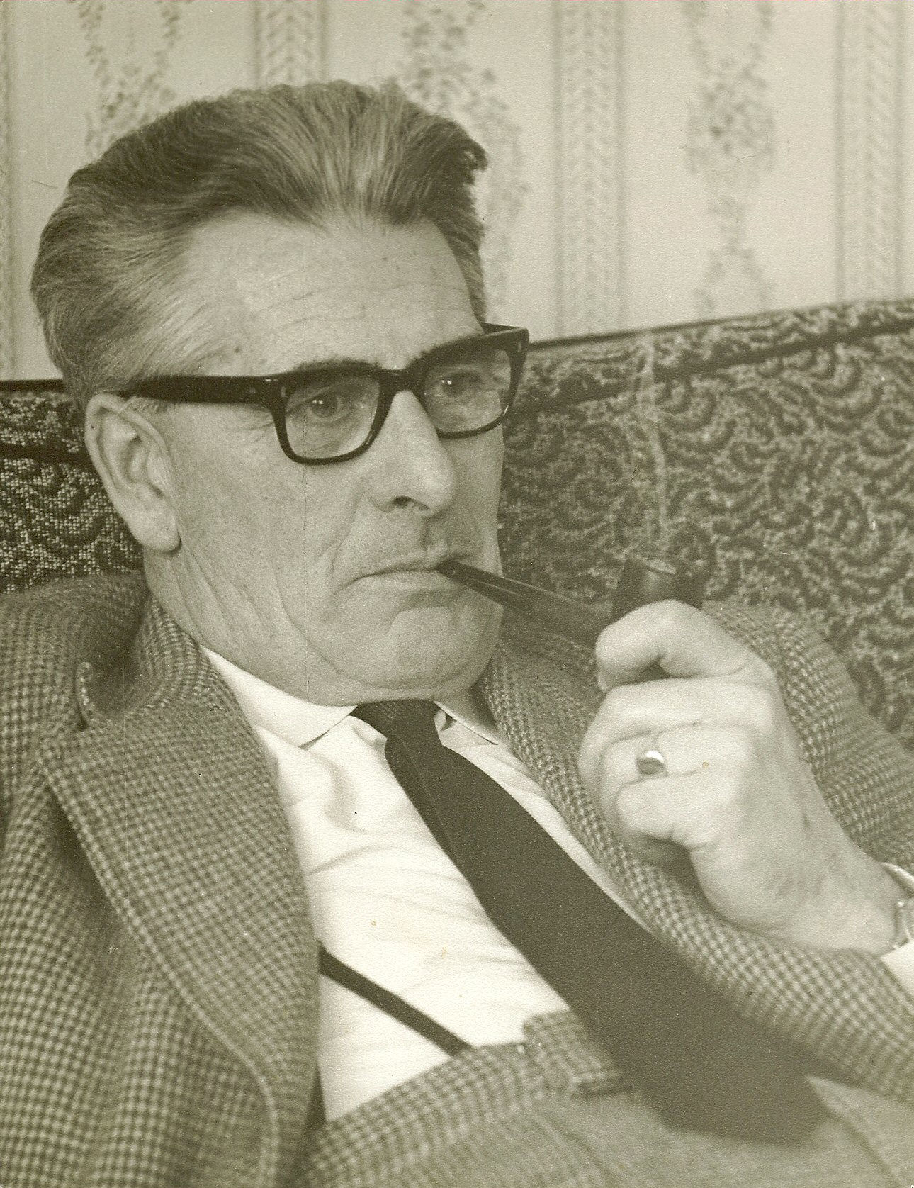 John Riley smokes a pipe.
