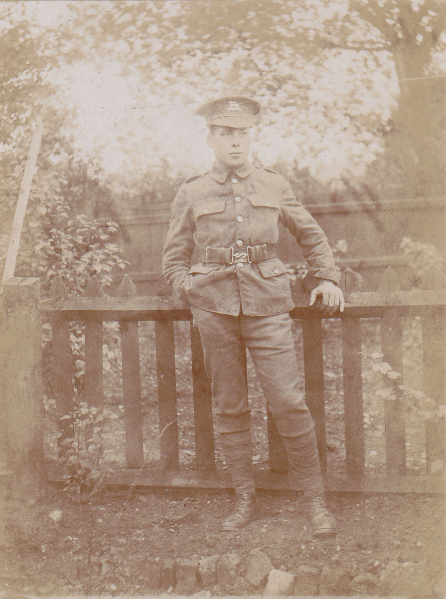 John James poses in uniform whilst leaning against a garden fence.