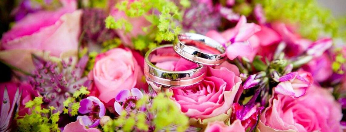 Two wedding rings on a bouquet of flowers.